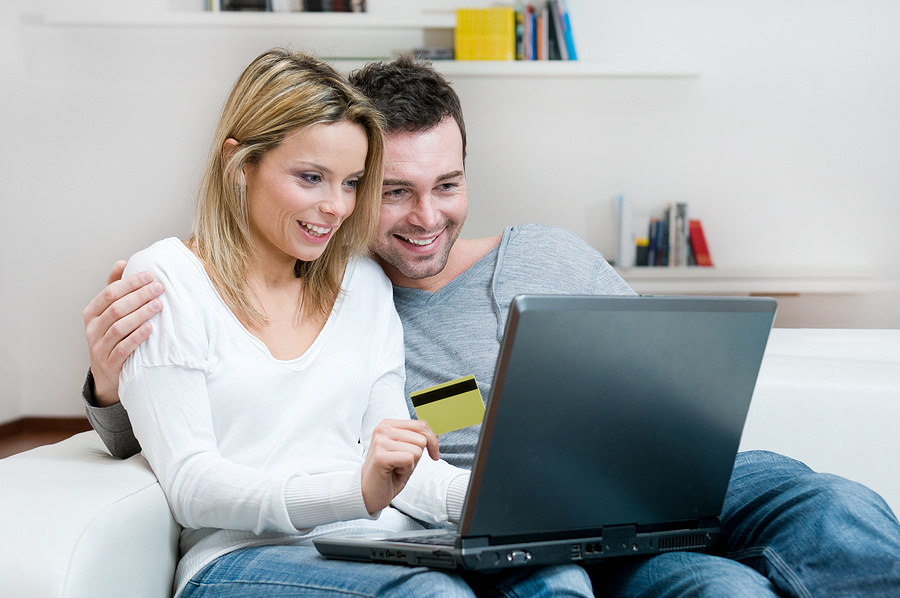 Young couple doing shopping in internet with credit card at home